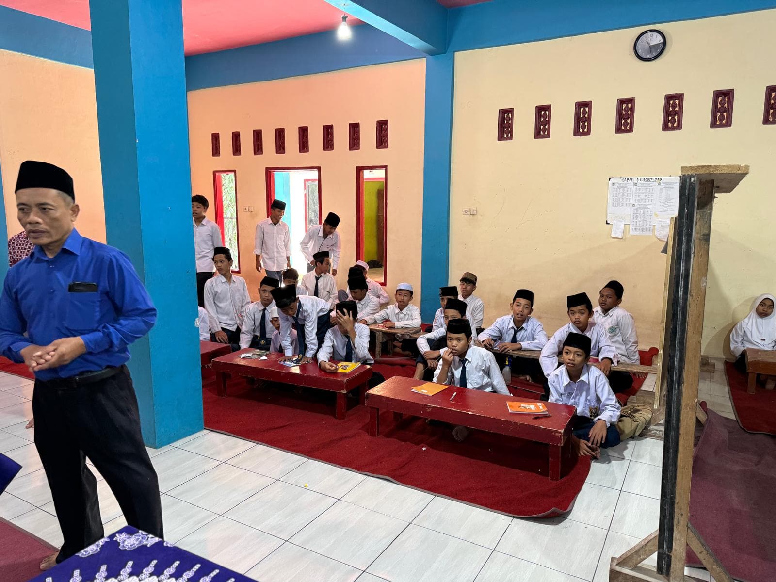 Guru membimbing santri yang belajar di aula